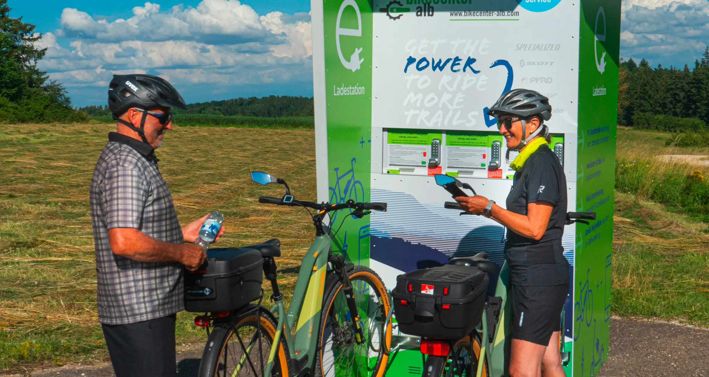 Ladestation Fahrradfahrer unterhalten sich vor der Ladestation